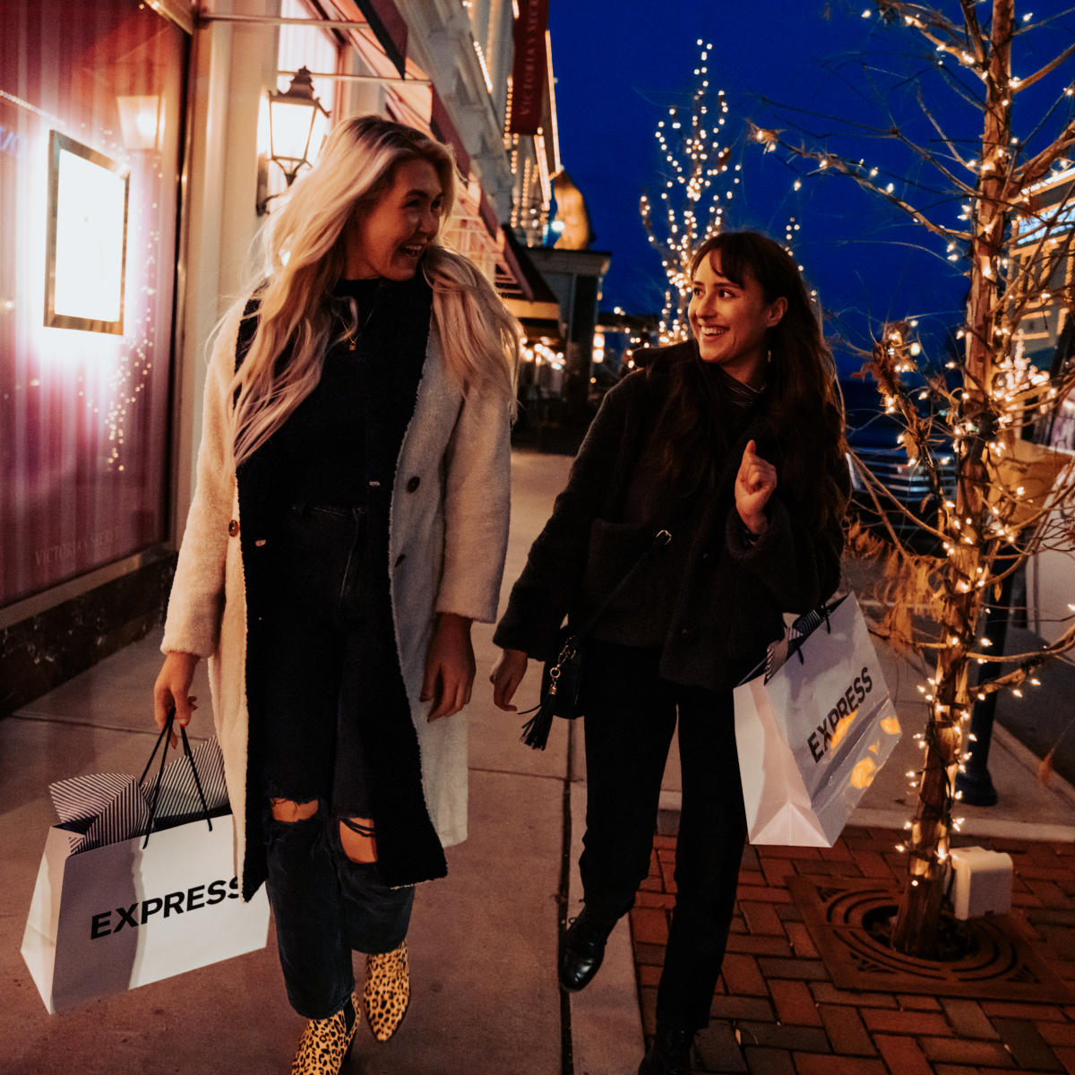 Two women holding Express bags while shopping at Easton