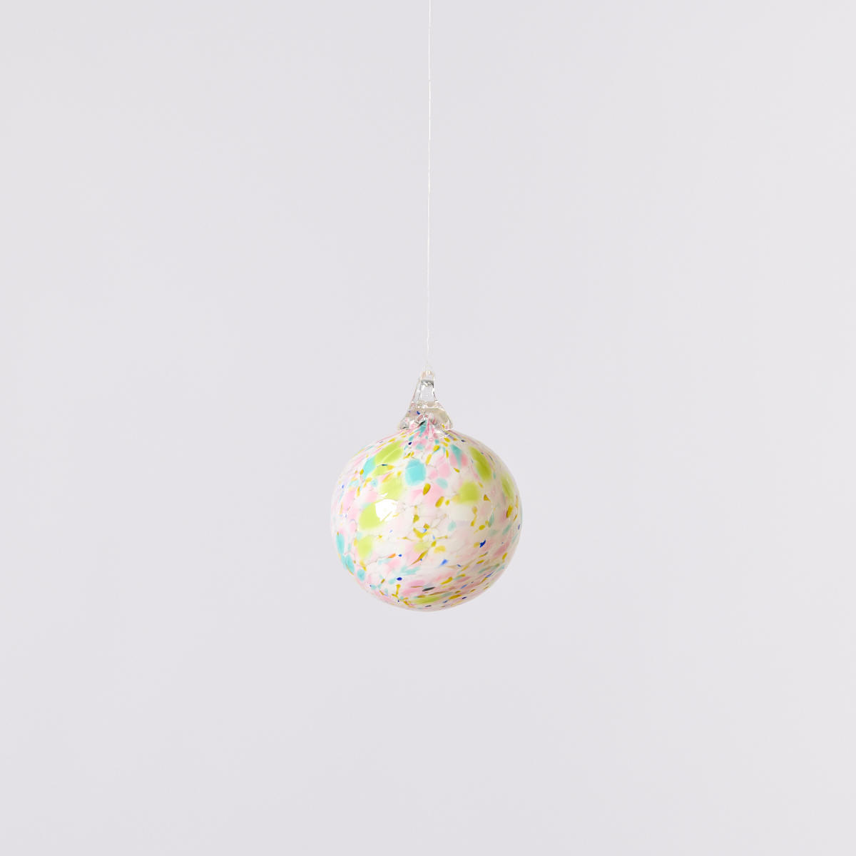 White glass ornament with light green, blue and pink splatterpaint from Columbus Glass Art Center