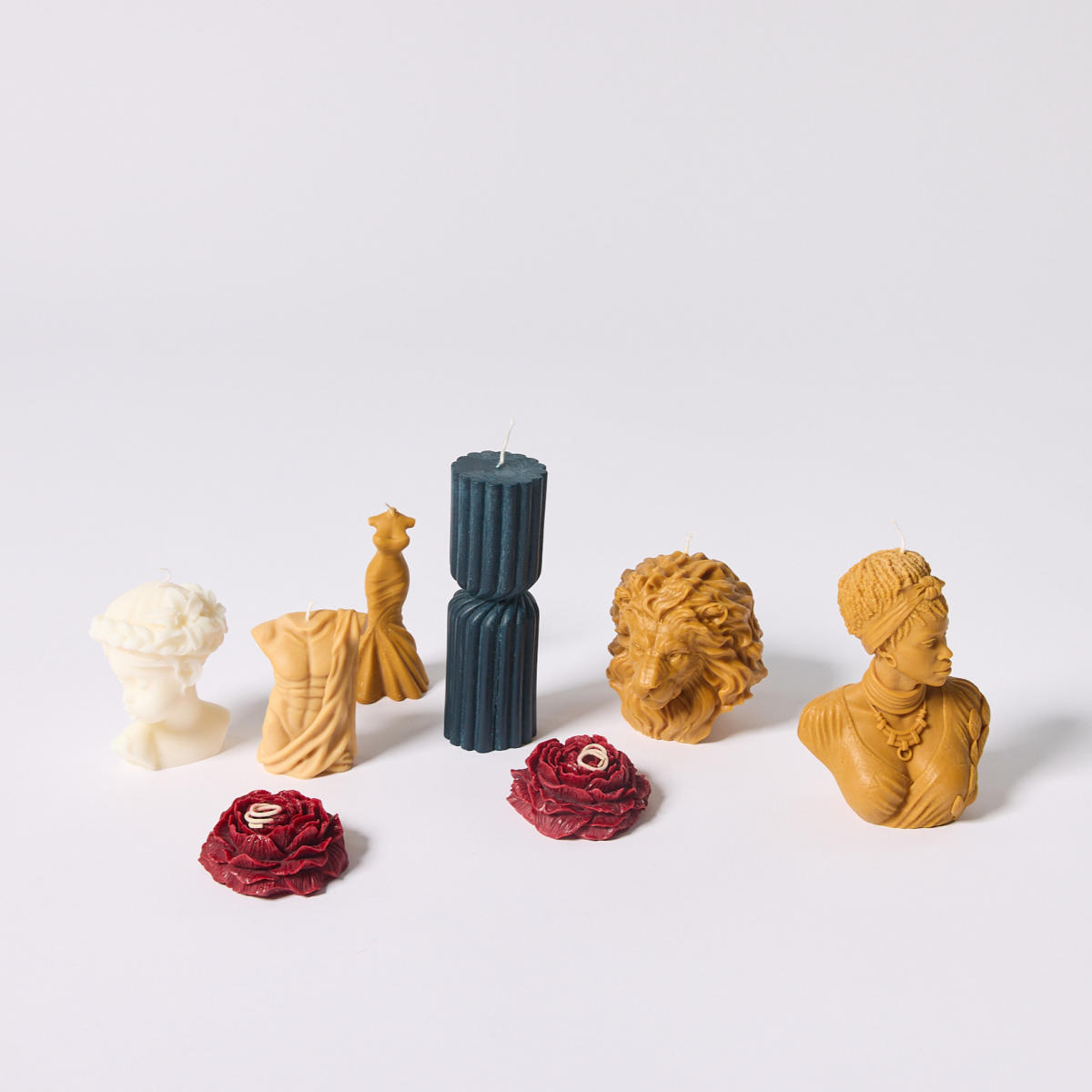 Colorful candles shaped like roman sculptures and flowers from Soleil Candle Collections