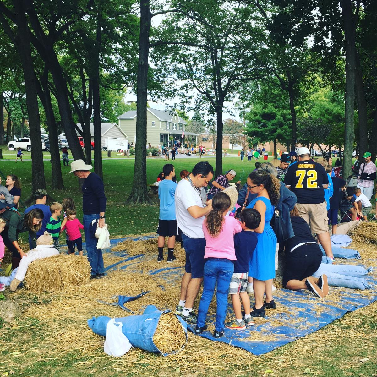 Visitors enjoy stuffing straw into makeshift scarecrows at the New Cumberland Apple Festival