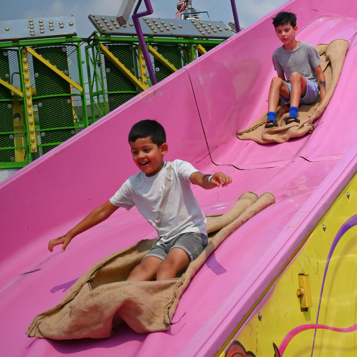 Two young boys riding down the giant slide at the Northern Wisconsin State Fair