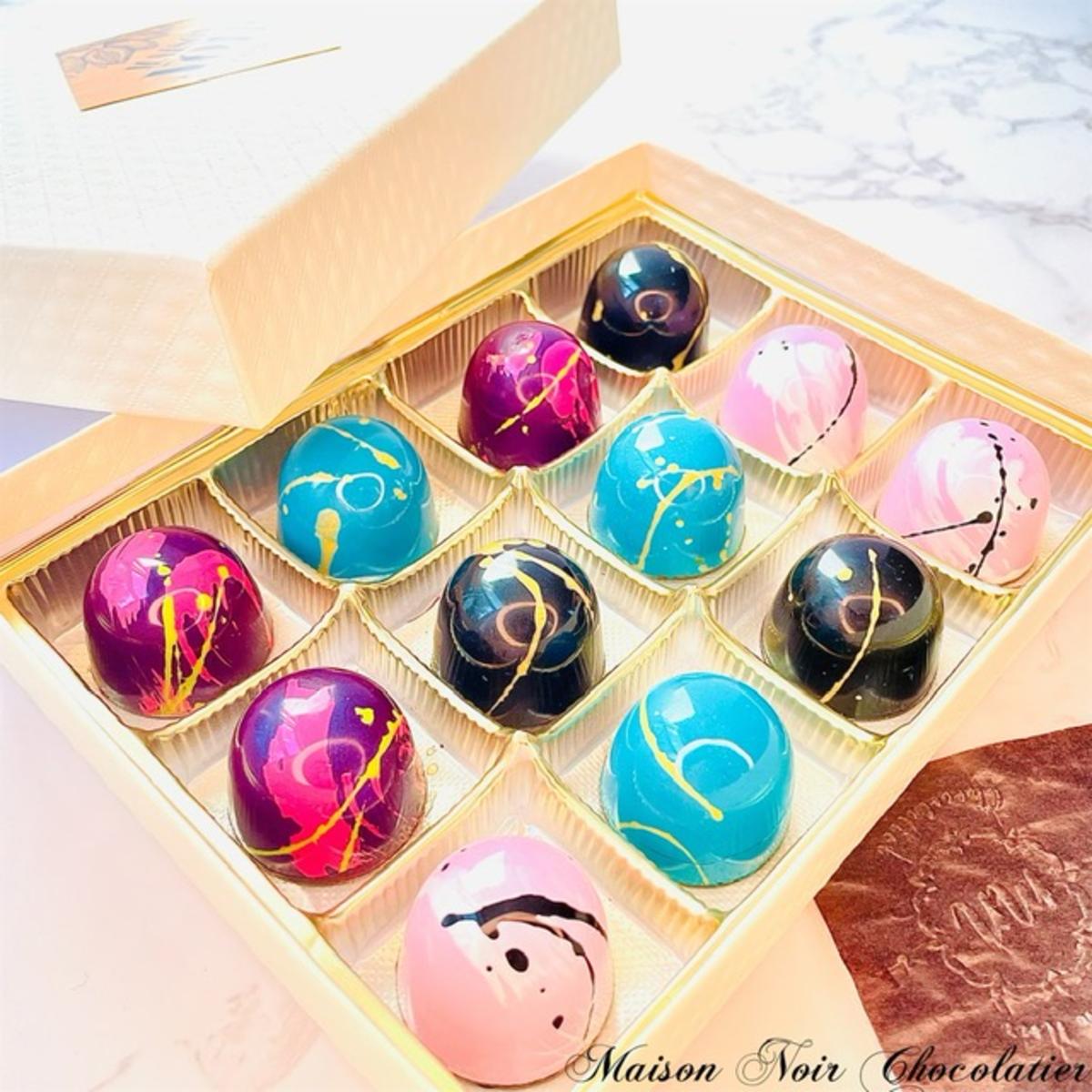 Tray of 12 chocolate bonbons in various bright colors