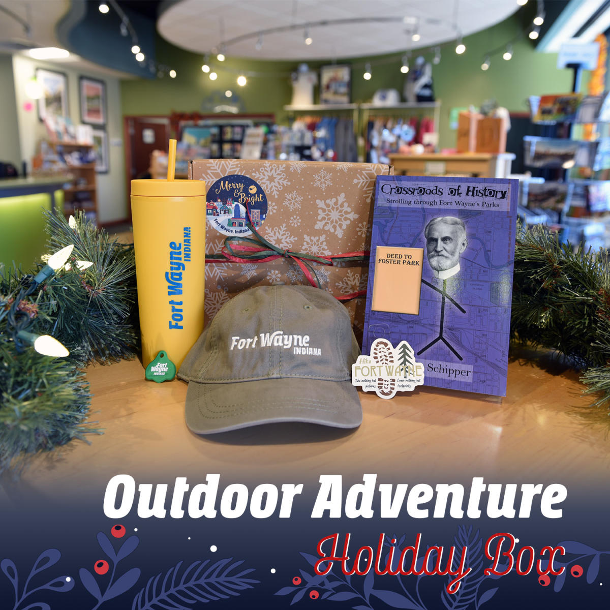 Gift box showing items including a thermos with straw, hiking sticker, Fort Wayne hat, Fort Wayne pop can opener, and Crossroads of History book