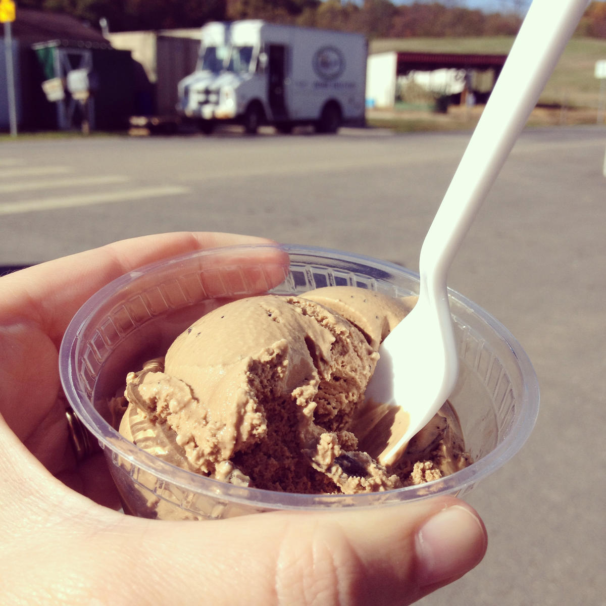 Hand holding a cup of chocolate ice cream from South Mountain Creamery
