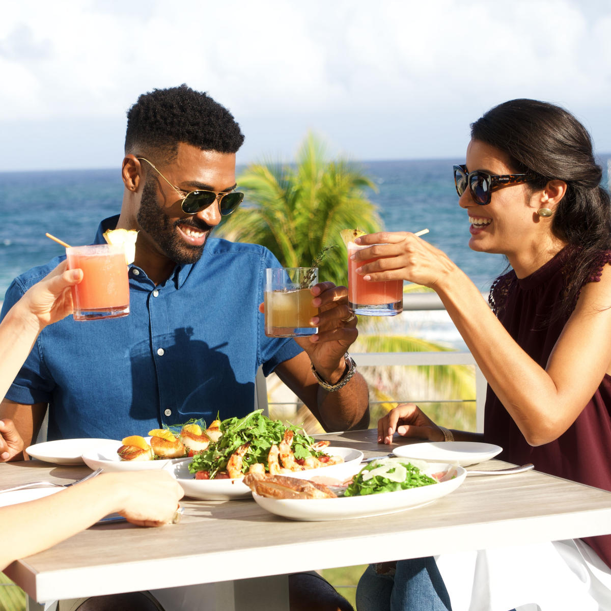 People holding up their glasses while dining on a patio in Fort Lauderdale