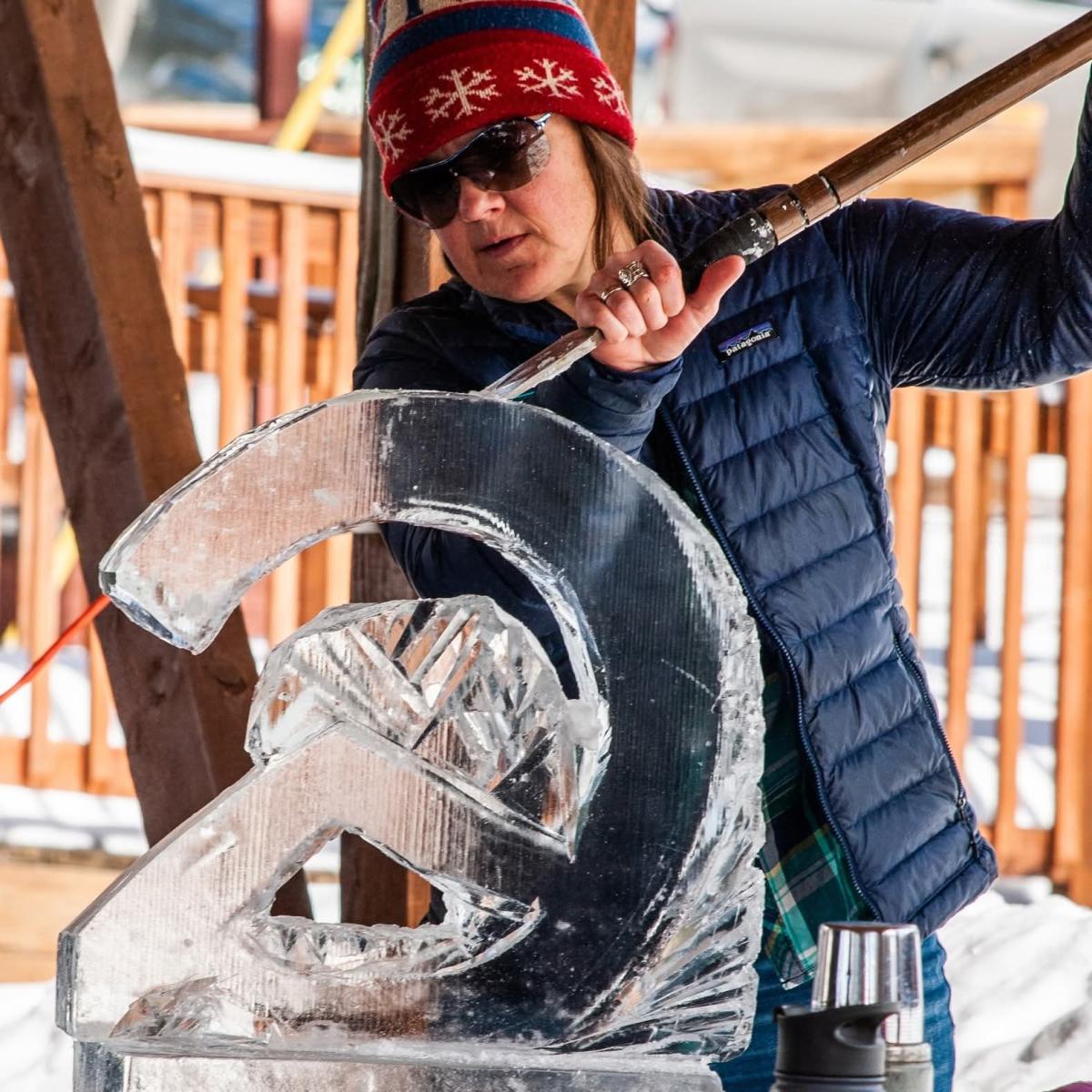 A woman carves a block of ice at Rocky Mountain Folk School's Ice Sculpting workshop at Grand Lake's Winter Carnival