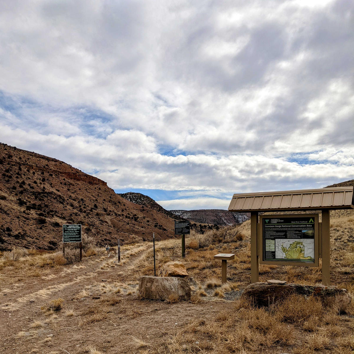 West River Trailhead with map and registration area surrounded by dirt and canyon walls in the Gunnison Gorge near Delta, Colorado.