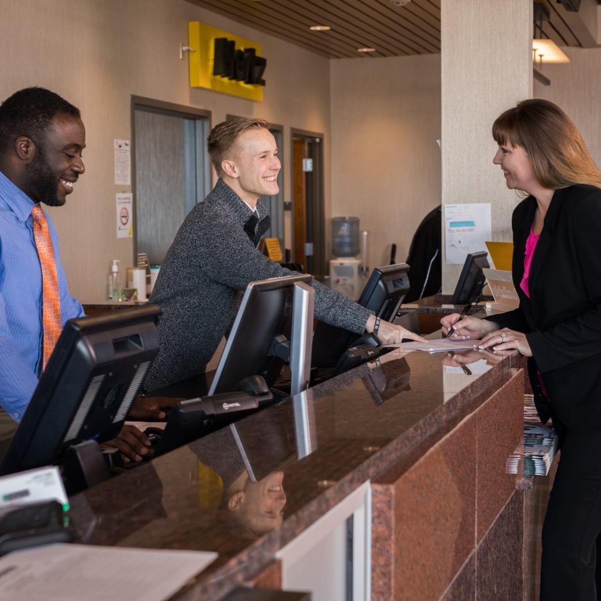 2 Men and one woman at the front counter of the Airport