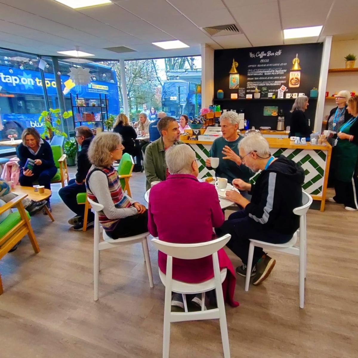 Group of people sitting inside Kadampa Meditation Centre's cafe
