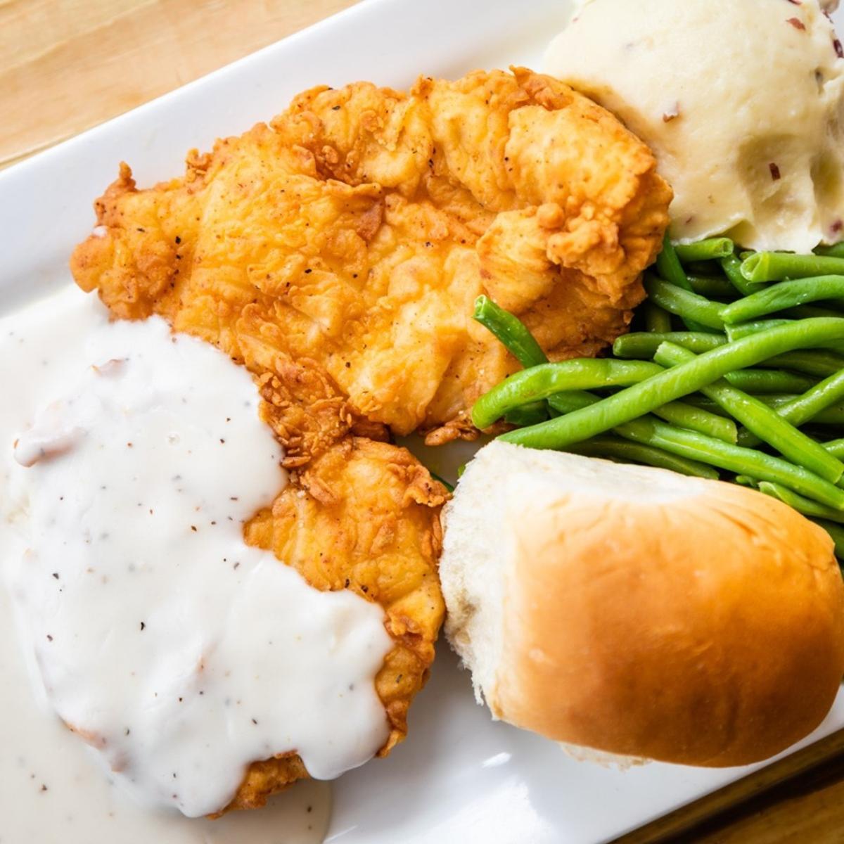 plate with chicken fried chicken, gravy, green beans and bread at Live Oak restaurant