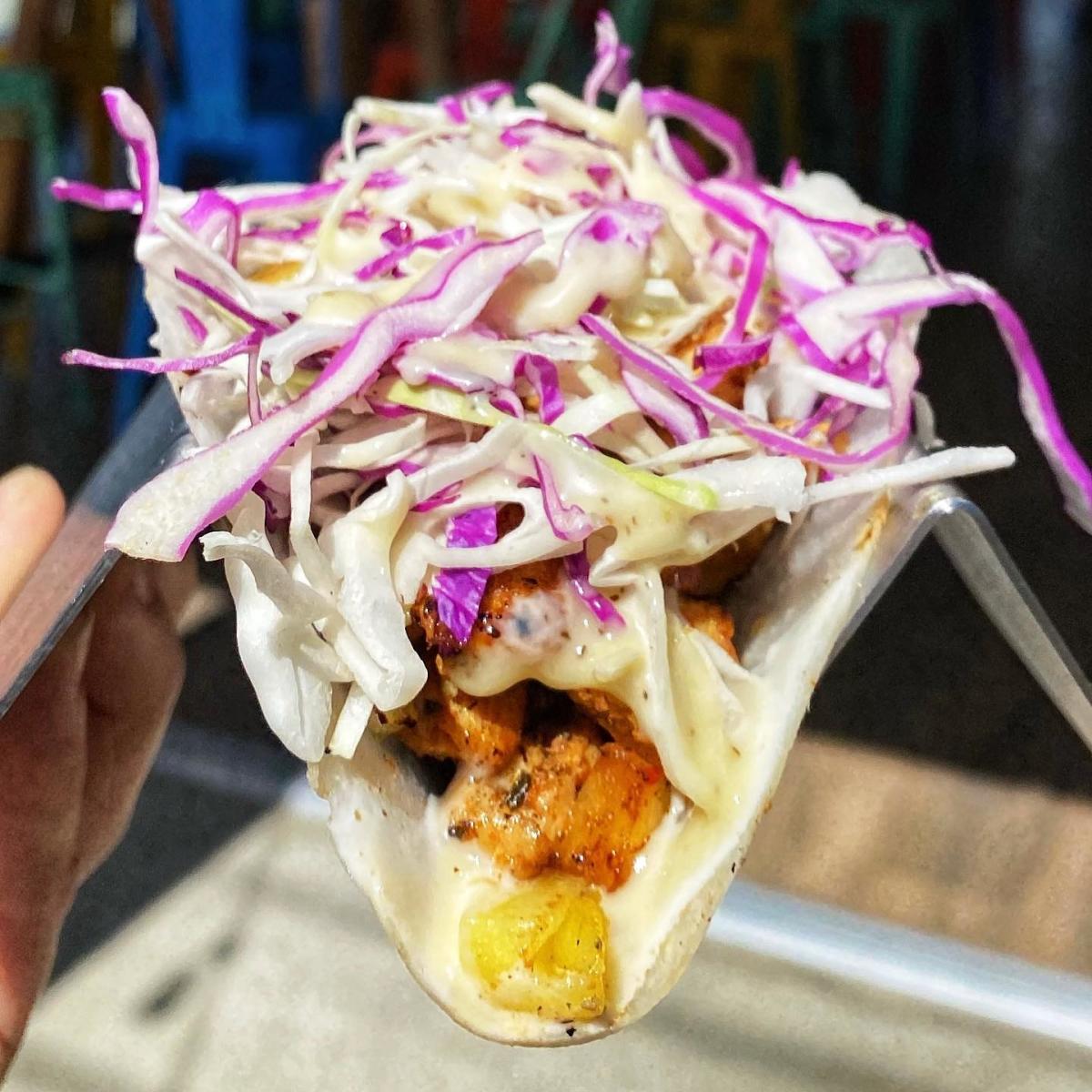 Jerk chicken taco on a bed of cabbage and jicama from Pacific Coast Tacos.