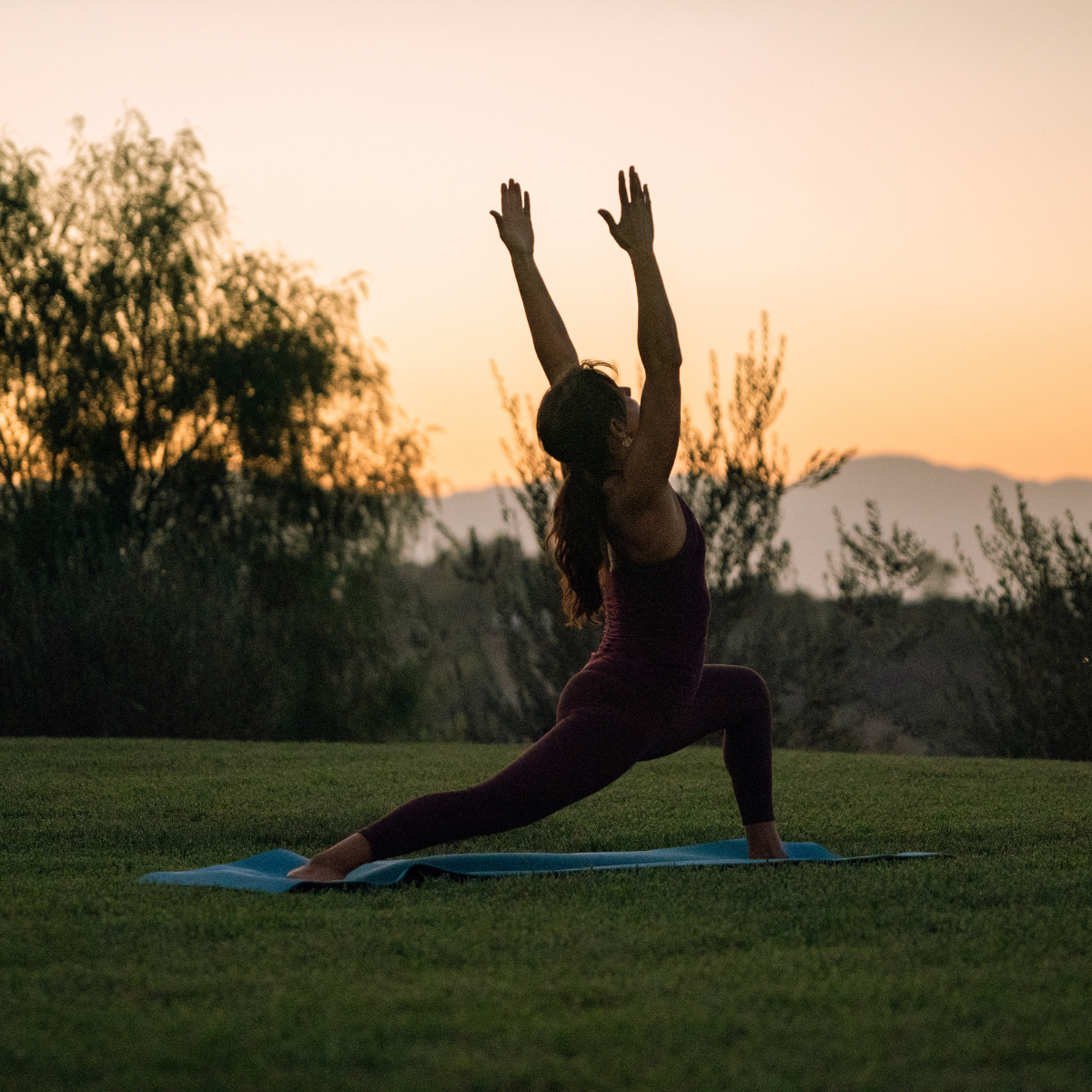 Woman doing yoga stretch at sunrise.