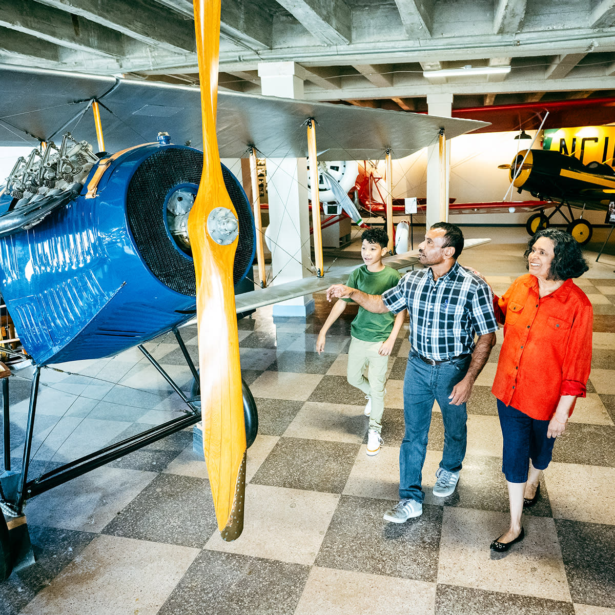 A man, woman and young boy look at an airplane on exhibit at the Kansas Aviation Museum.