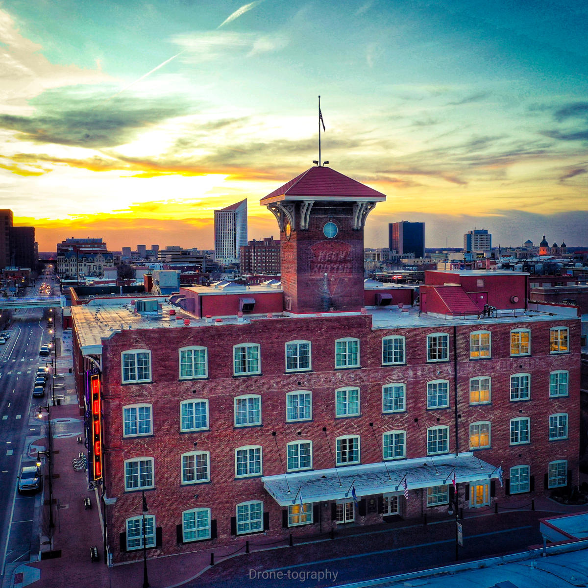 An photo features the Hotel at Old Town with the downtown Wichita skyline in the background at dusk