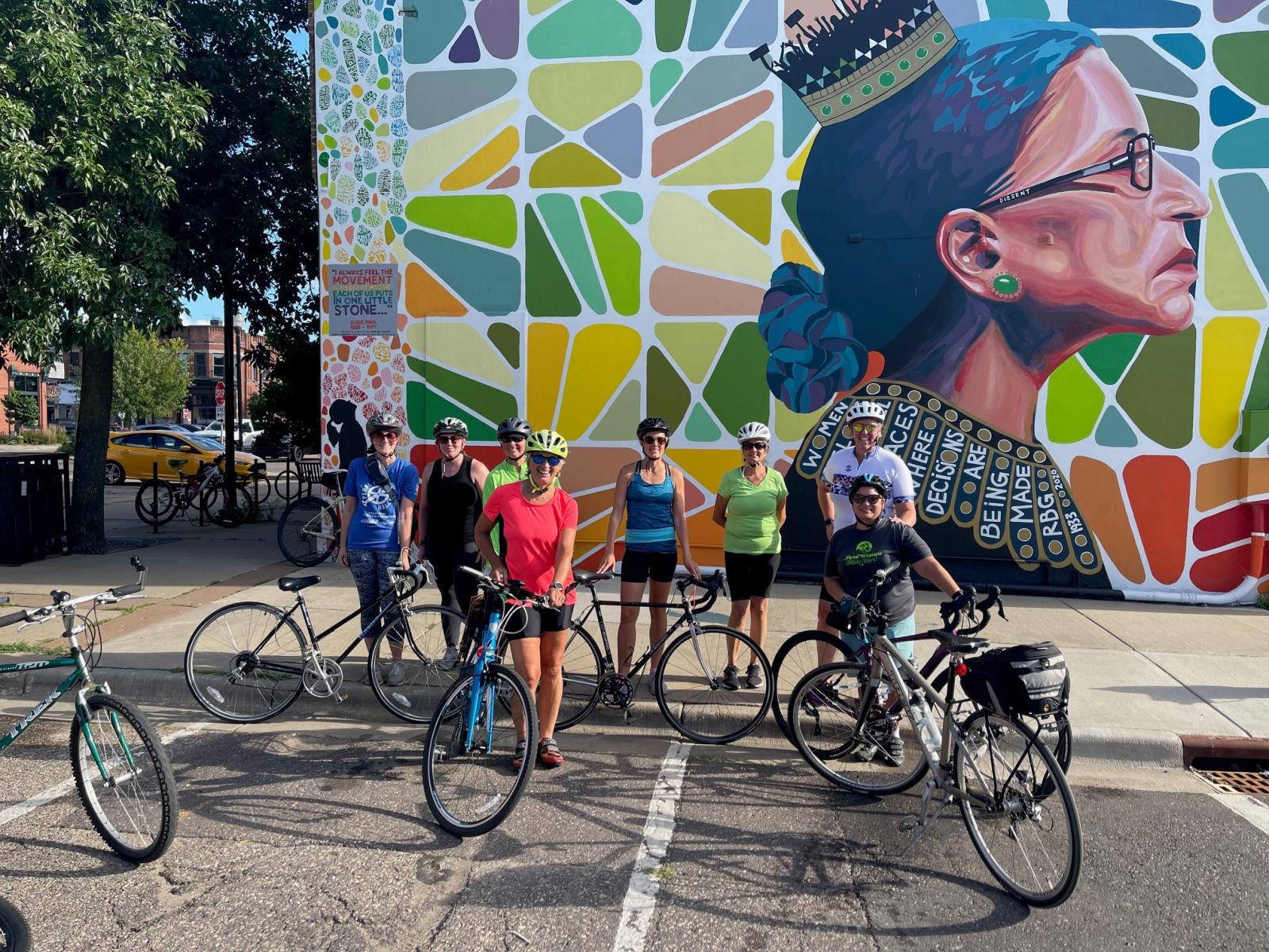 Girls on Gravel biking group in central Wisconsin posing in front of the Ruth Bader Ginsberg mural in downtown Stevens Point.