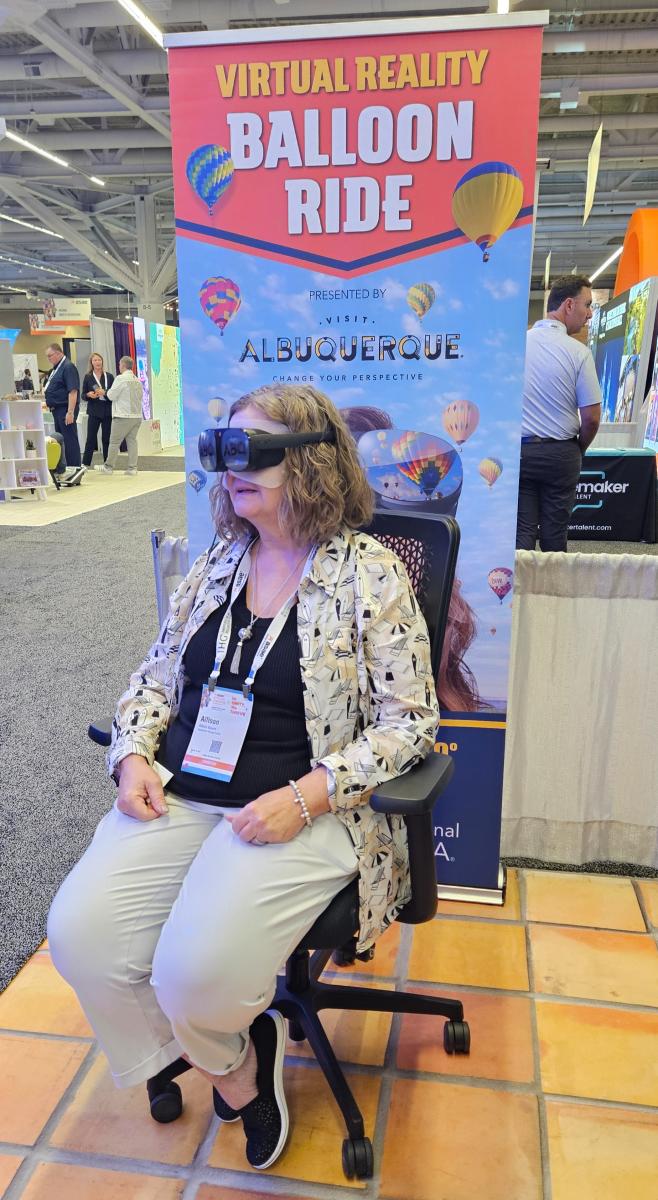 Someone sits in a chair and participates in a virtual balloon ride at the ASAE annual meeting.
