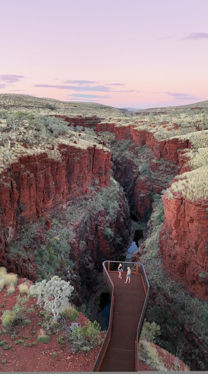 Two people standing on the 360 degree Knox Gorge Lookout at sunset