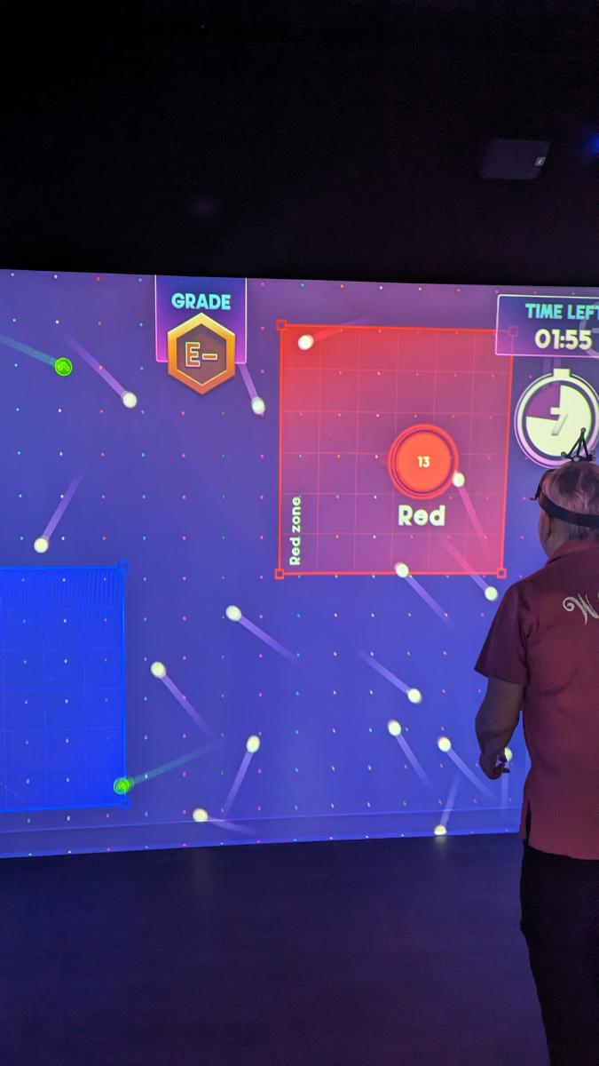 Image is of a person playing a game on the projected wall.