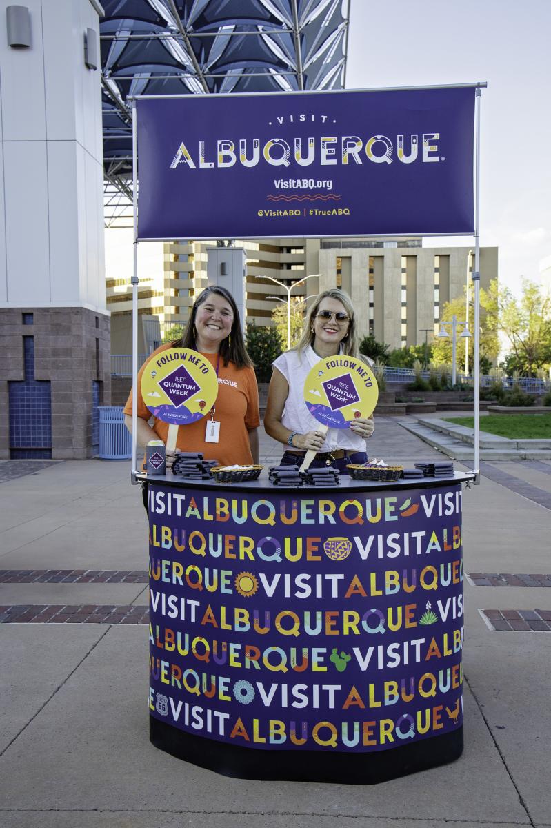 Brooke and Tania stand at the Visit Albuquerque pop-up booth during an event at IEEE Quantum Week.