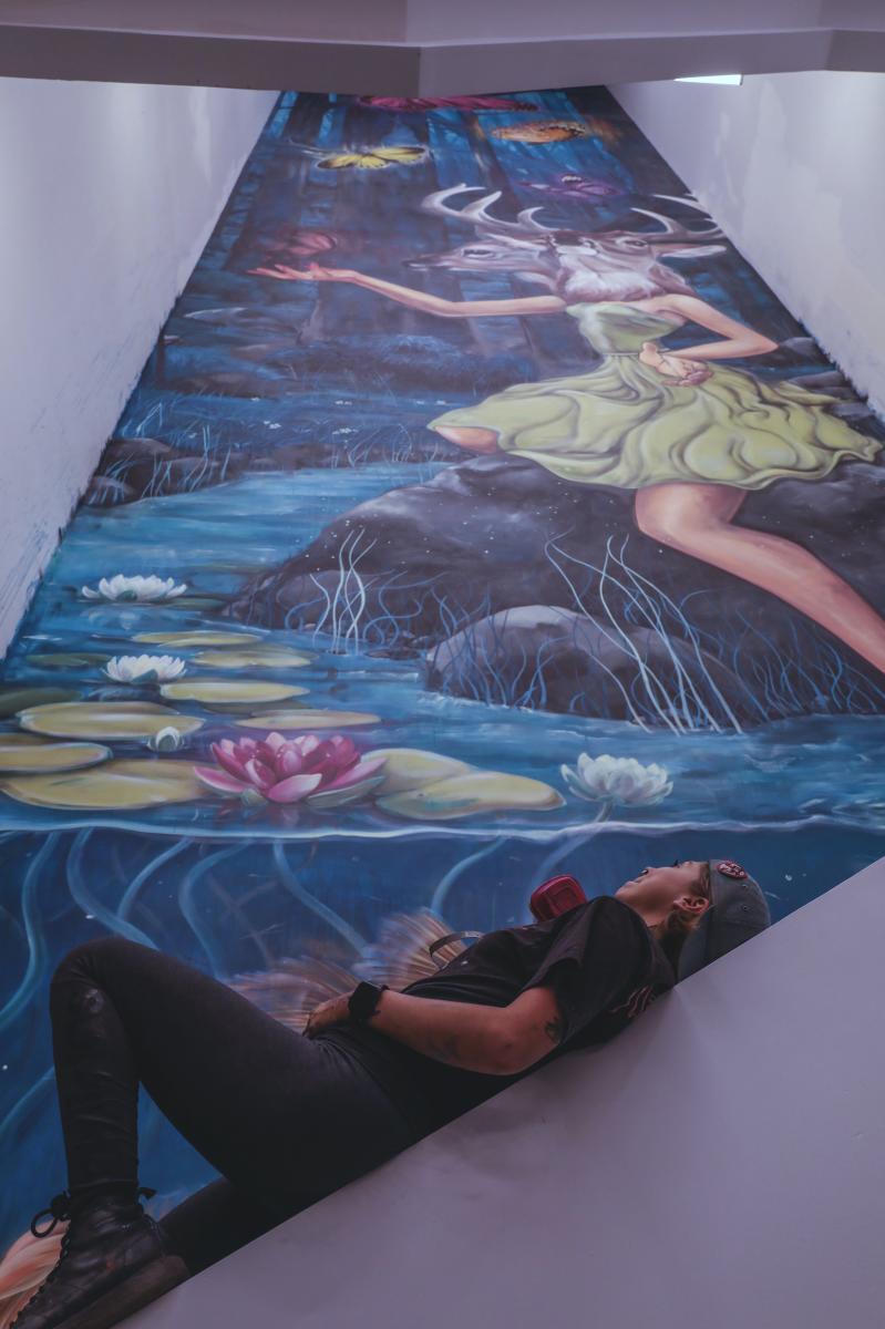 Mandi Caskey viewing her 90ft mural inside Gravity