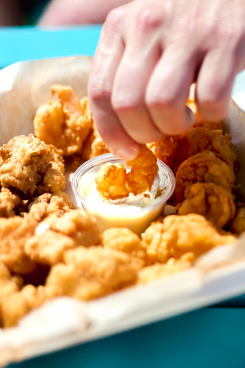 Dipping Shark Shack shrimp into sauce 