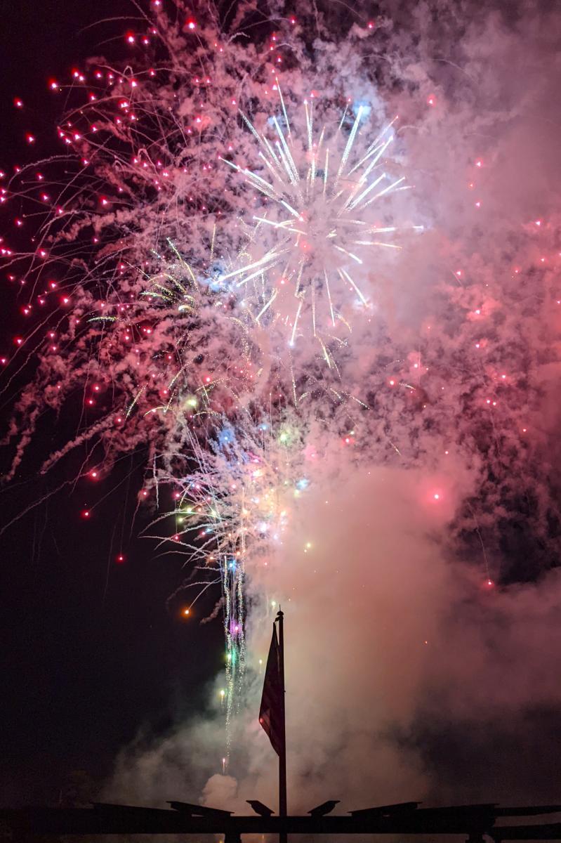 Red fireworks explode over the flagpole at Northshore Park.