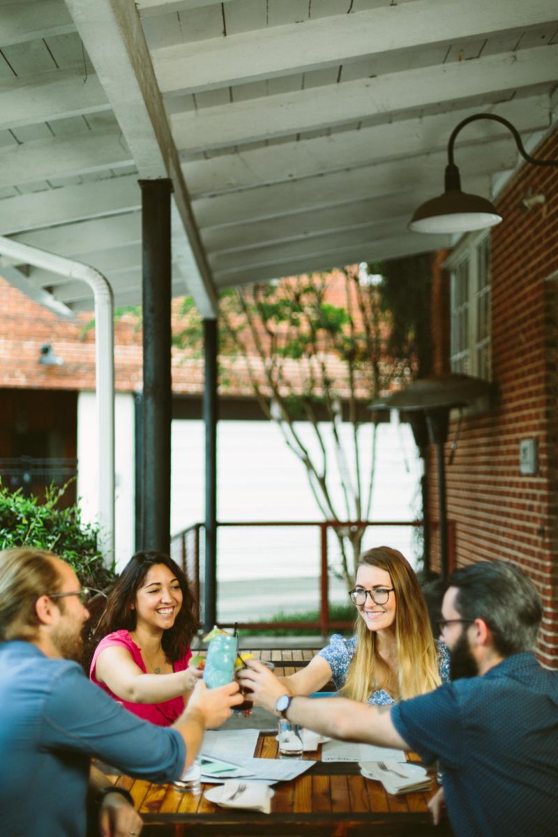 A group of friends cheers on the patio at Seabear Oyster Bar in Athens, GA.
