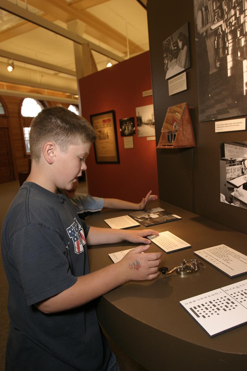 Young boys read a display and try out a telegraph machine at the Cheyenne Depot Museum