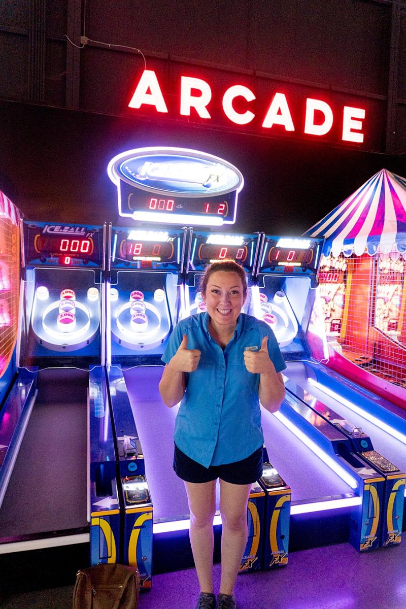 mom with a thumbs up in an neon-lighted arcade