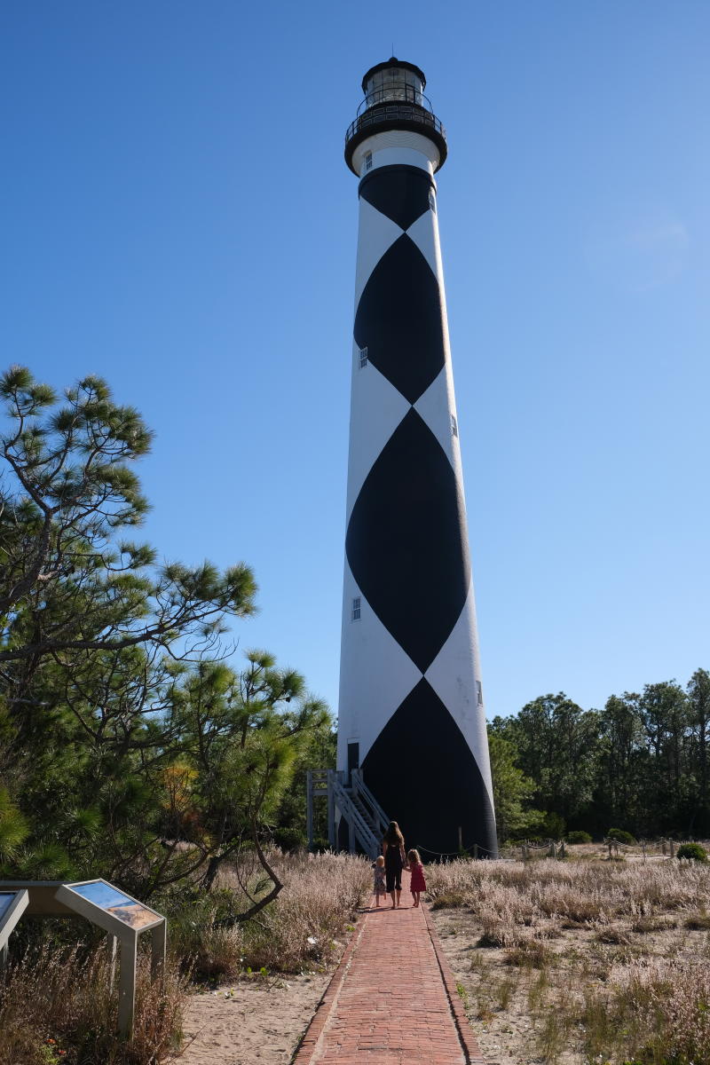 The black-and-white exterior of the Cape Lookout Lighthouse shines bright in the coastal sun.