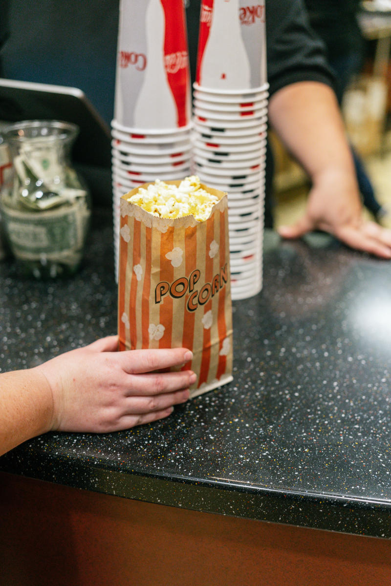 a close-up of a customer reaching for a bag of popcorn