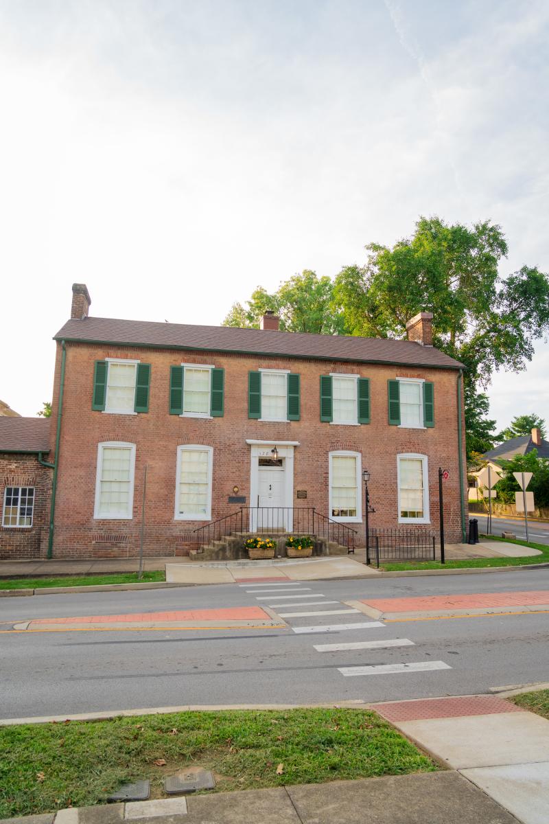 Historic brick building with green shutters, located in Elizabethtown, Kentucky, on a quiet street corner