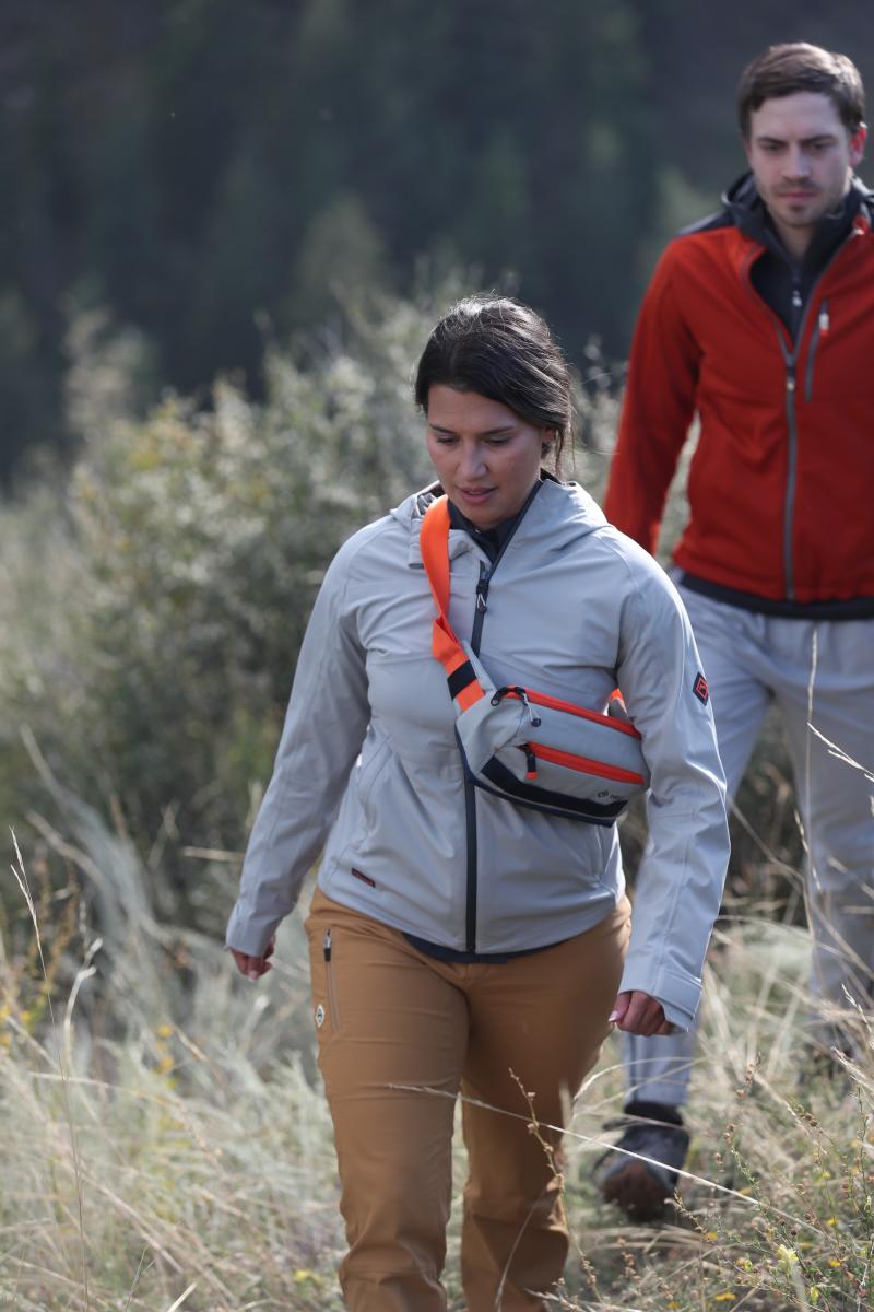 Woman hiking with tellus grey jacket and sling bag