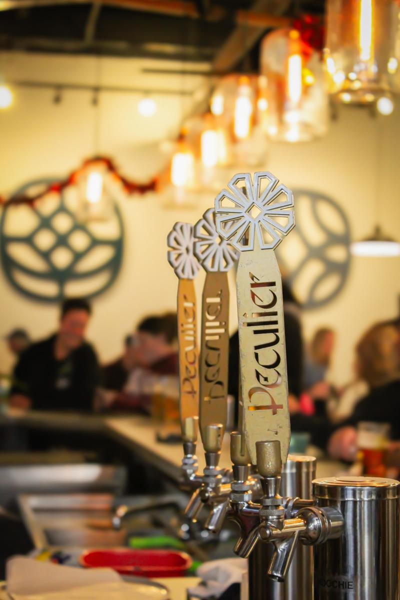 A row of tap handles that say Peculier on them