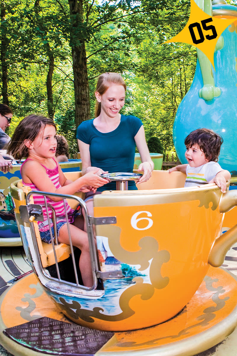 a mom, daughter and son riding a teacup amusement park ride at Idlewild Park