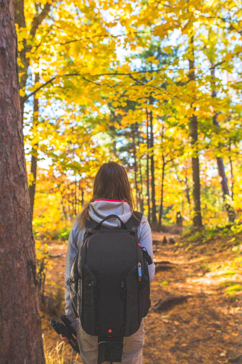 A woman hiking among the fall foliage in Big Bay, MI