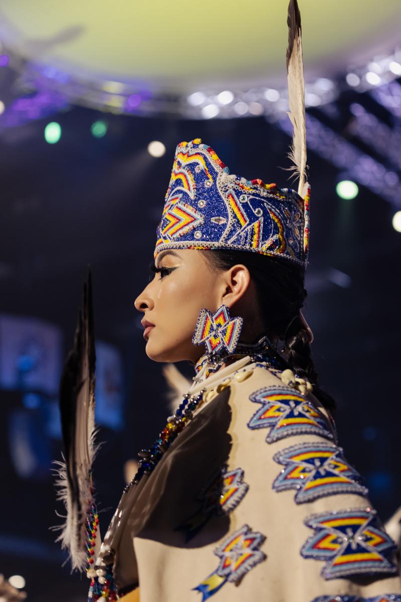 A young participant during the powwow’s Grand Entry wears an ornately beaded crown and a single eagle feather to signify purity.