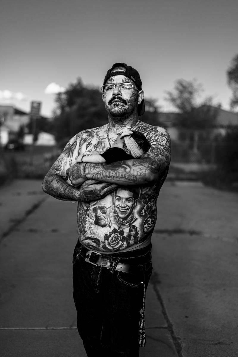 A father, Matthew Pete “Goof” Cordova, holds his six‑day‑old daughter Ava during a nighttime cruise on Fourth Street in Barelas.