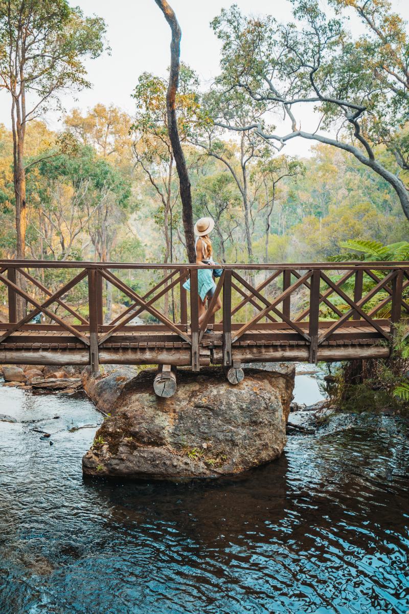 Girls walks across a bridge at Araluen Botanic Park in Armadale