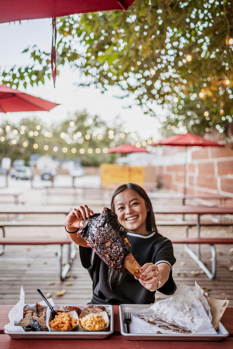 Influencer Rachel Kawate holds up a massive beef rib from Black's BBQ in San Marcos, Texas.