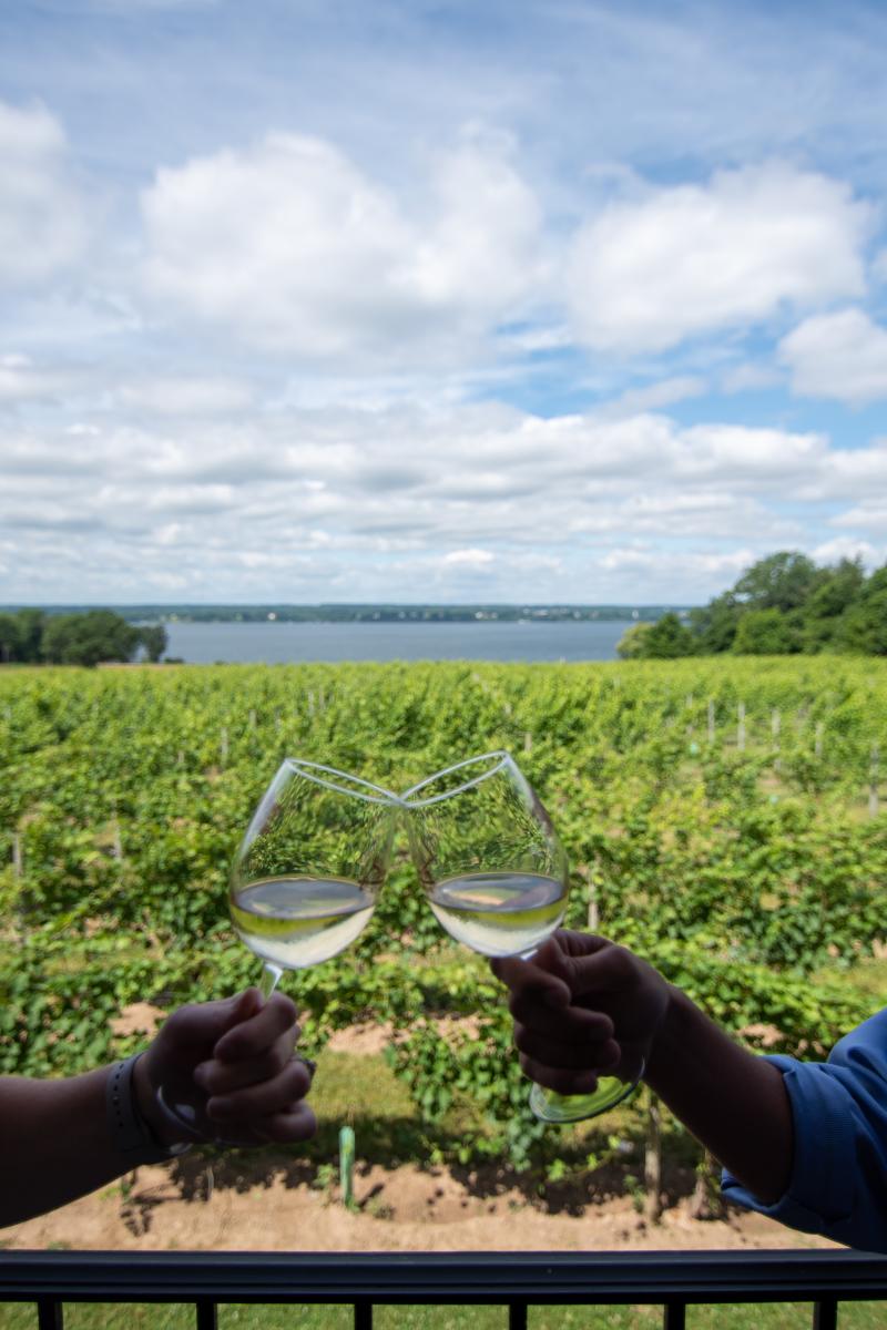 Couple holding wine glasses at Ventosa Winery with lake in background