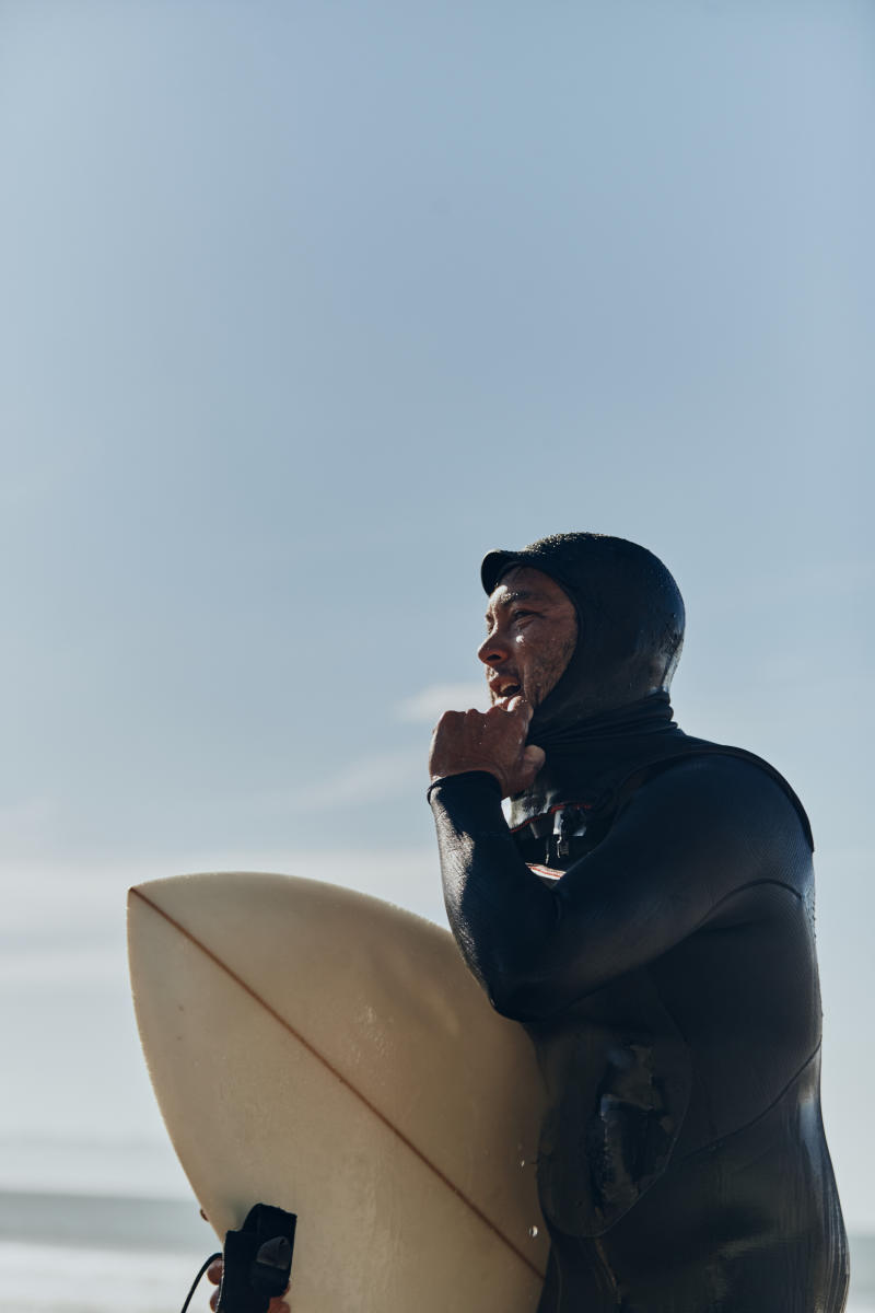 Aaron Jackson holding his surf board.