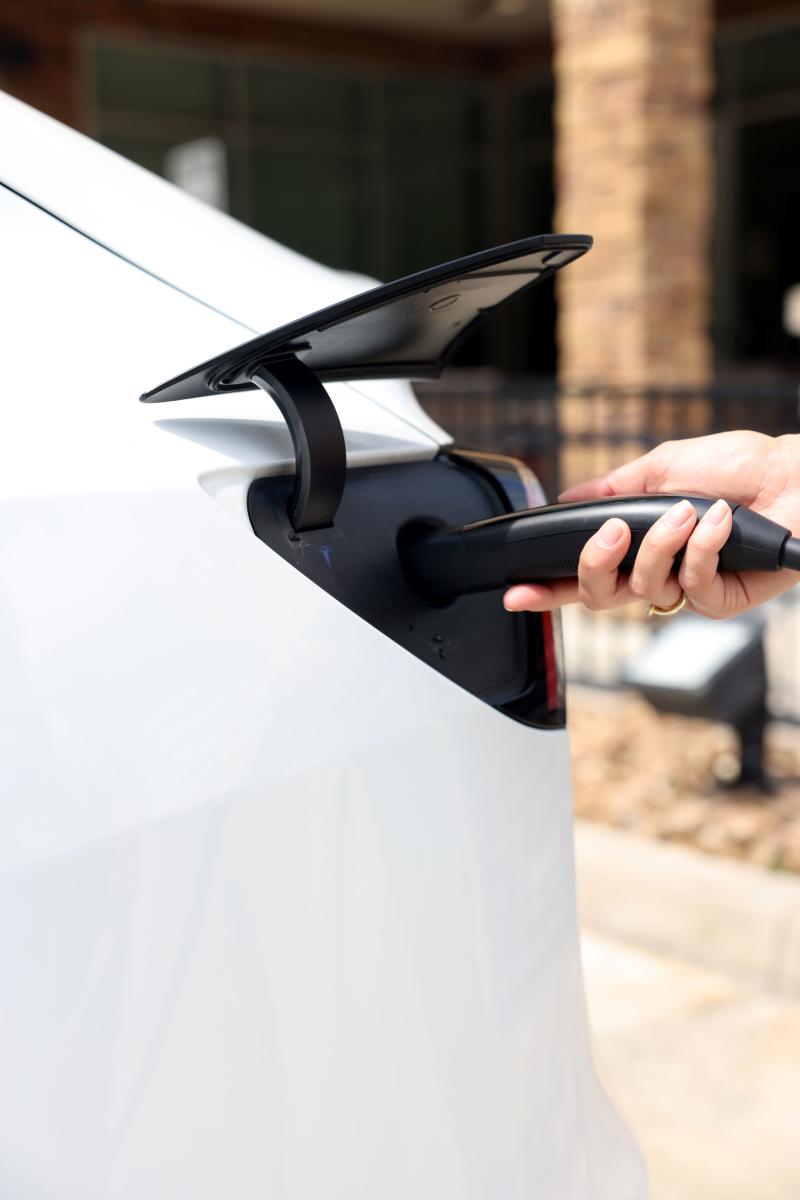 Woman charging her Tesla at Hyatt Place in The Woodlands, Texas