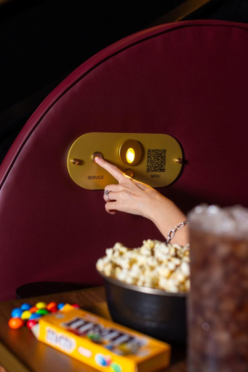 Person pressing call button at Reel Luxury Cinemas in The Woodlands, Texas