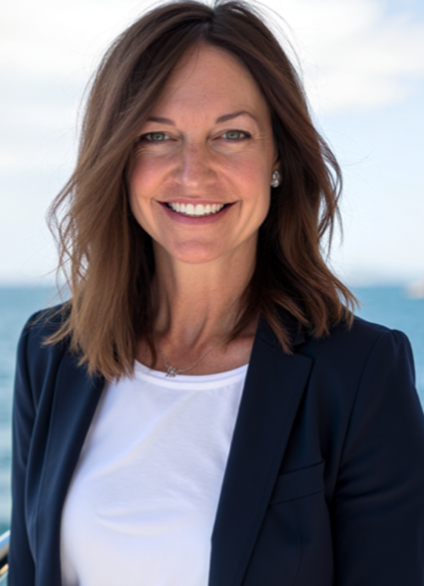 This image shows Economic Development Coordinator Melissa Marmitt. The image is a professional headshot of Melissa smiling and wearing a white shirt under a black suit jacket.