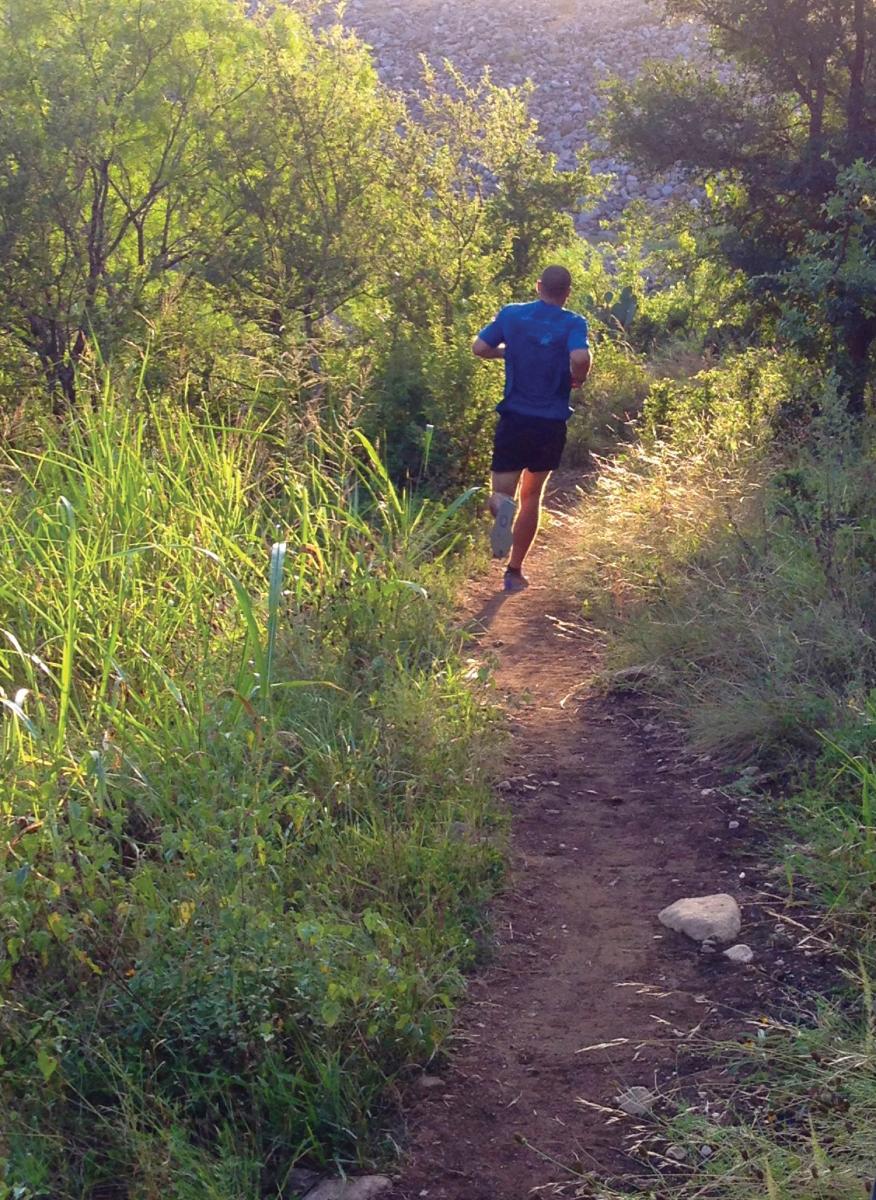Man running in Purgatory Creek Natural Area in San Marcos, Texas