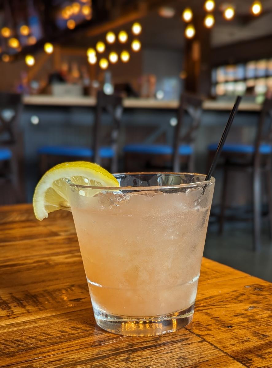Image is of the Dixie Land Delight cocktail with a straw and lemon.