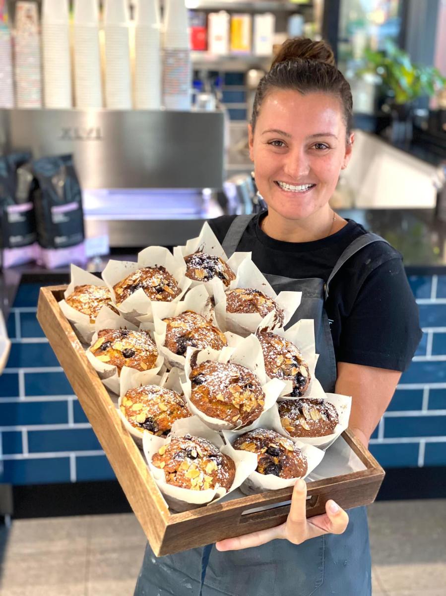 Baker holding a tray of large muffins at Short St Cafe, Broome