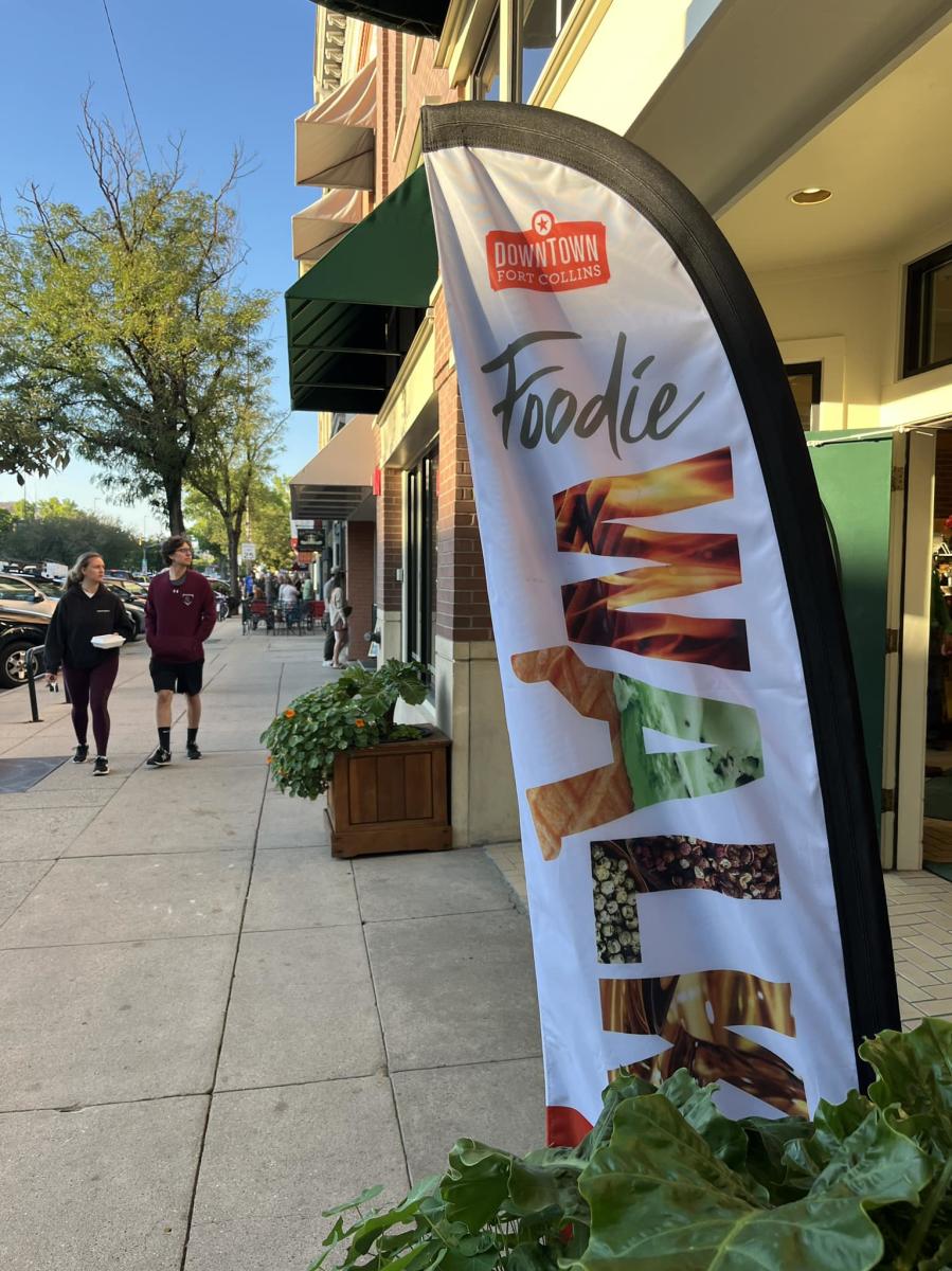 People walk down a street in Fort Collins attending the Foodie Walk