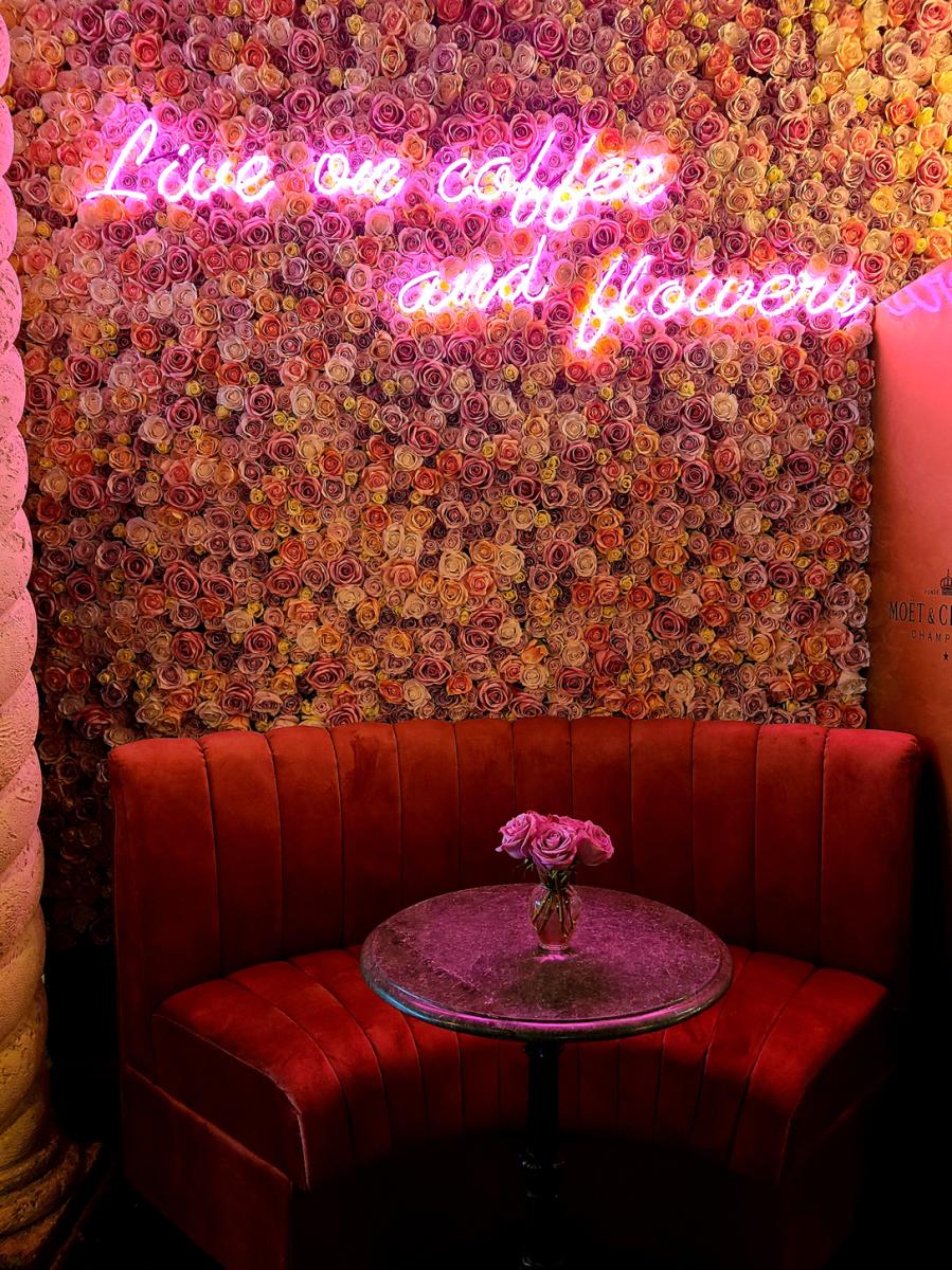 A Booth With Roses On The Wall At Ann's Florist and Coffee Bar
